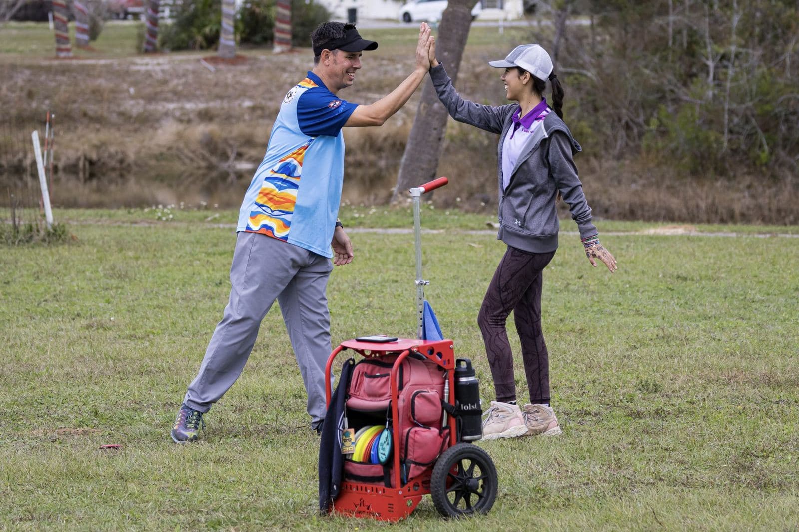 Doubles partners high-five on the fairway.